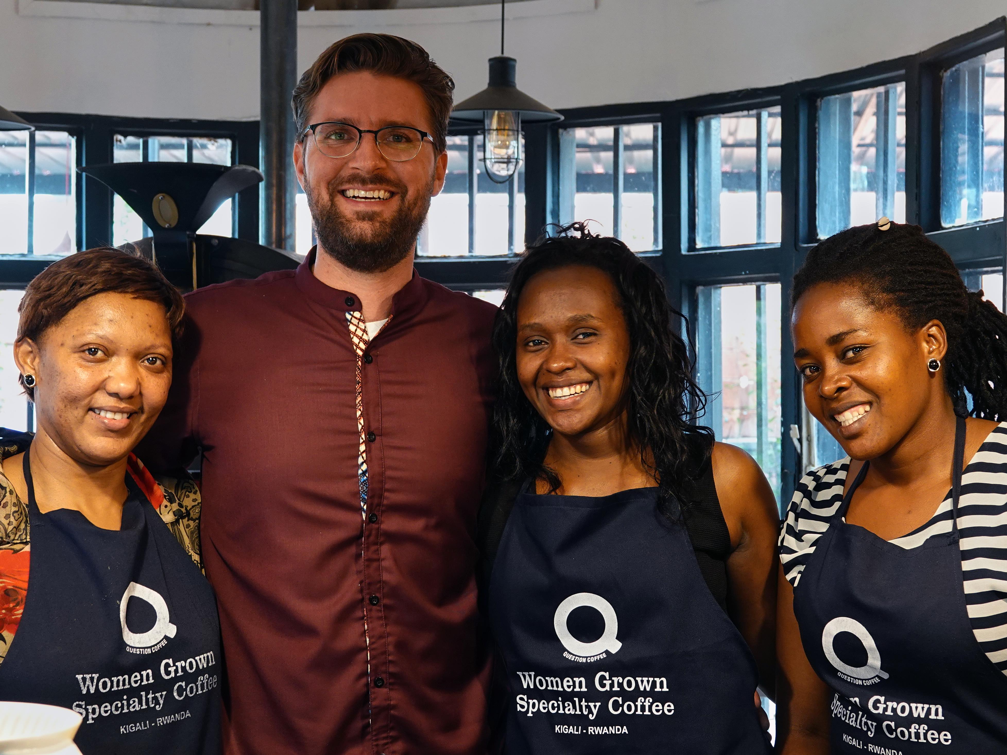 L’homme d’affaires Adam Mclean et trois travailleuses en tablier, tous souriants.