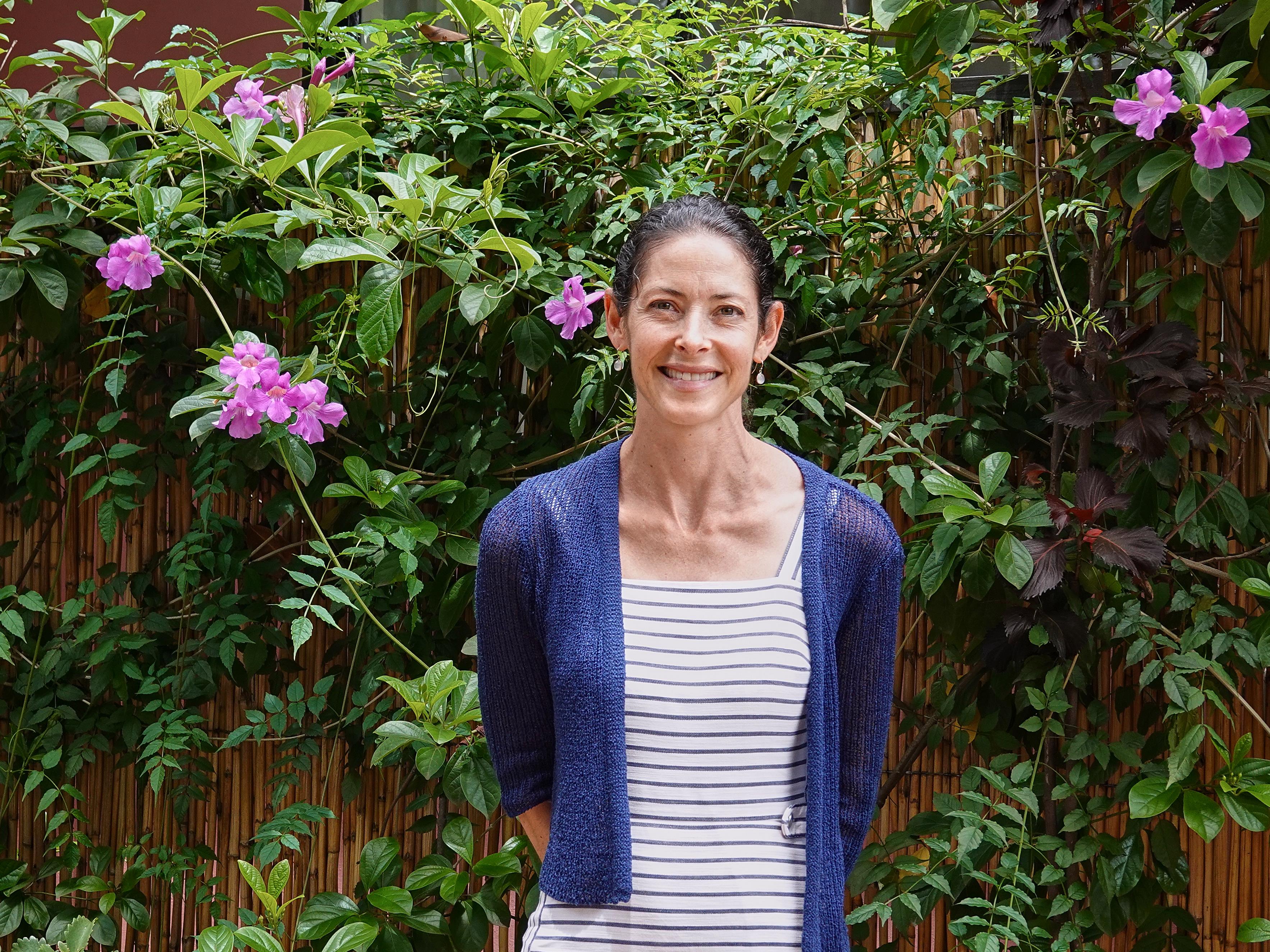Alissa Ruxin, souriante, entourée d’une végétation luxuriante.