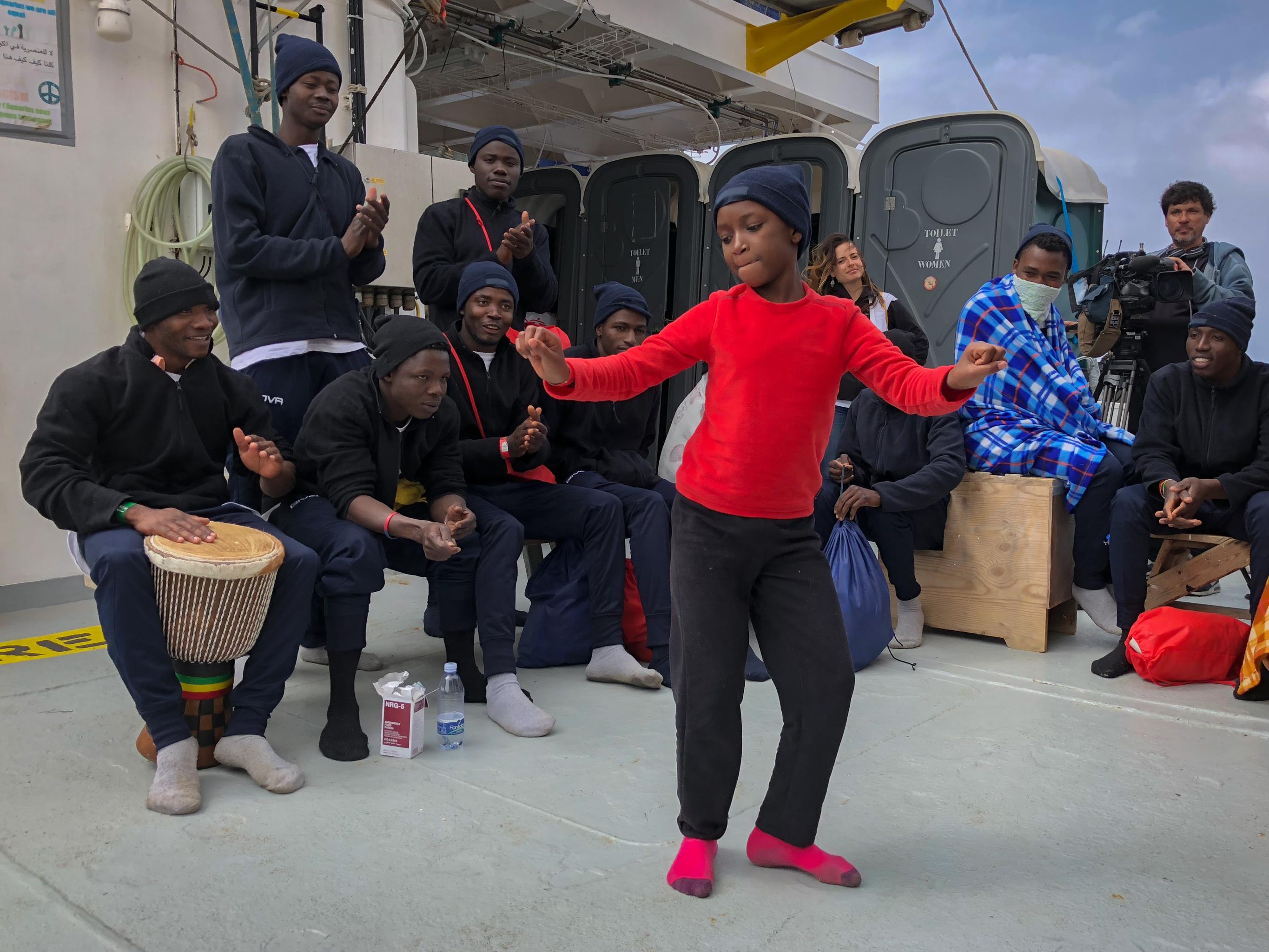 Une jeune migrante dansant au son du djembé