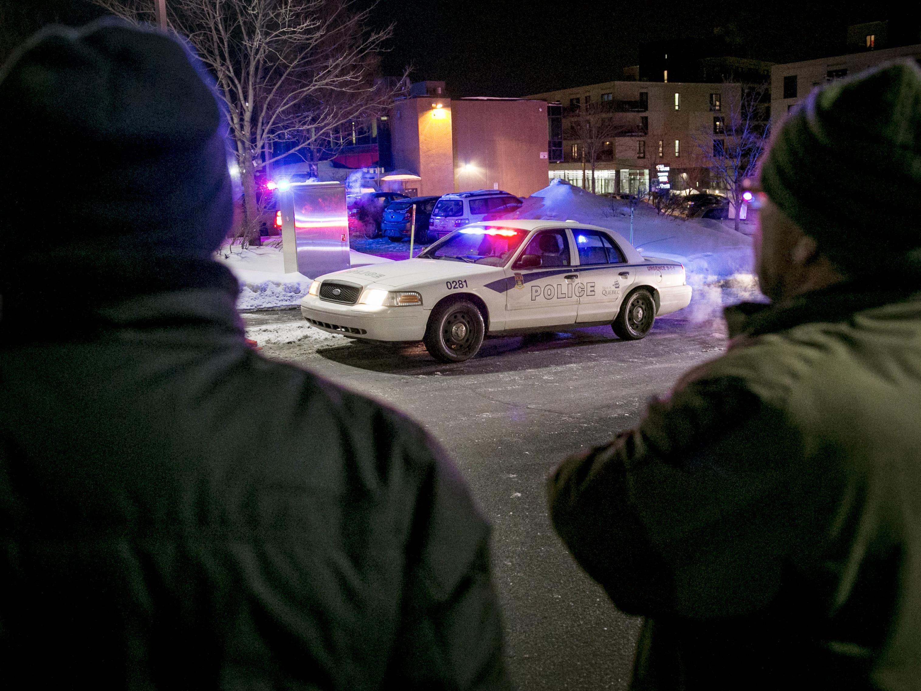Deux hommes regardent la grande mosquée de Québec dans les instants après l’attentat
