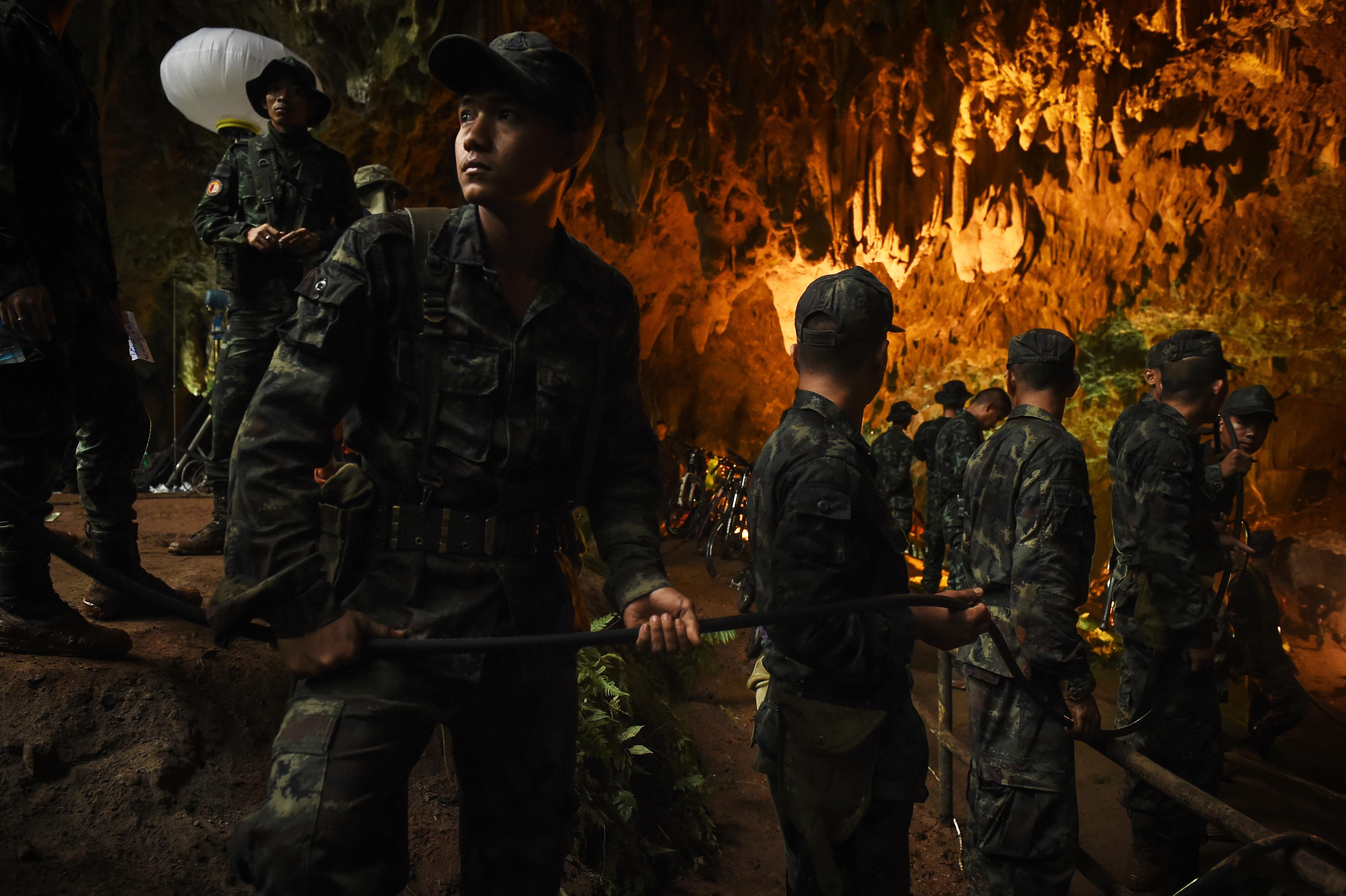 Des soldats thaïlandais installent des fils électriques dans la grotte de Tham Luang, dans le parc de Khun Nam Nang Non, à Chiang Rai, le 26 juin 2018.