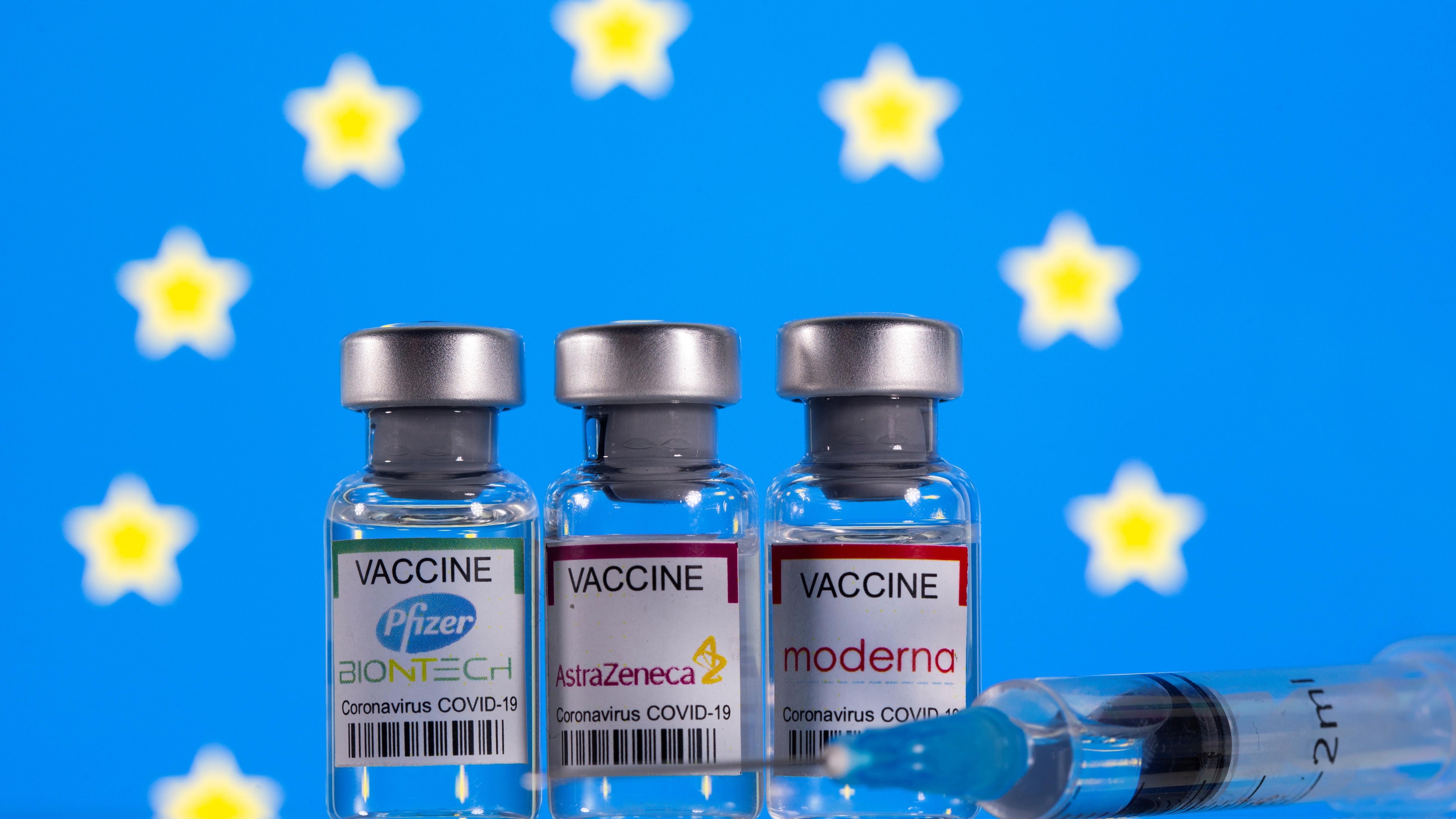 Viales con etiquetas de vacunas contra el coronavirus (COVID-19) de Pfizer-BioNTech, AstraZeneca y Moderna con una bandera de la UE.