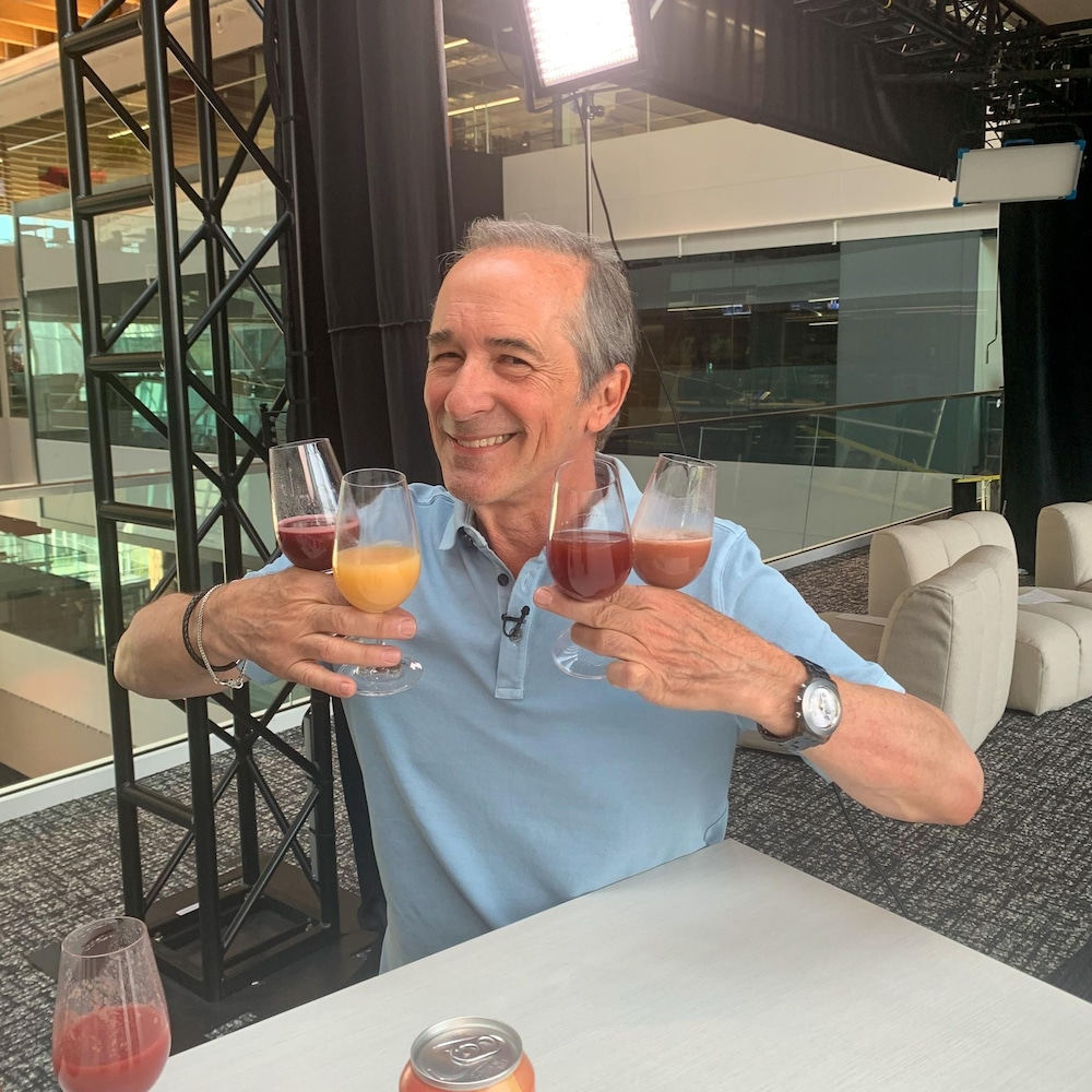 Denis Gagné tient 4 verres de jus dans ses mains.