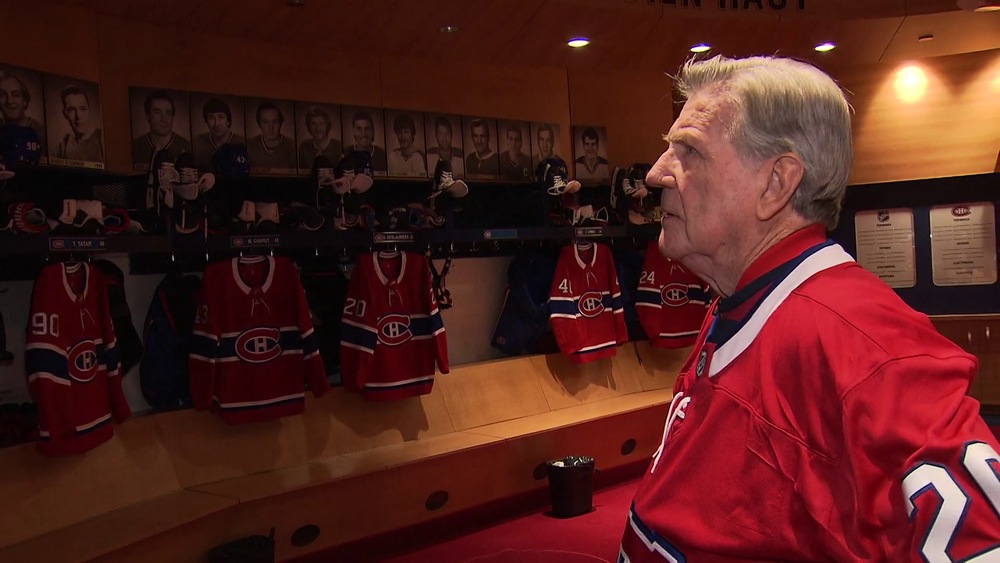 Phil Goyette regarde les portraits des anciens joueurs du Canadien affichés dans le vestiaire.