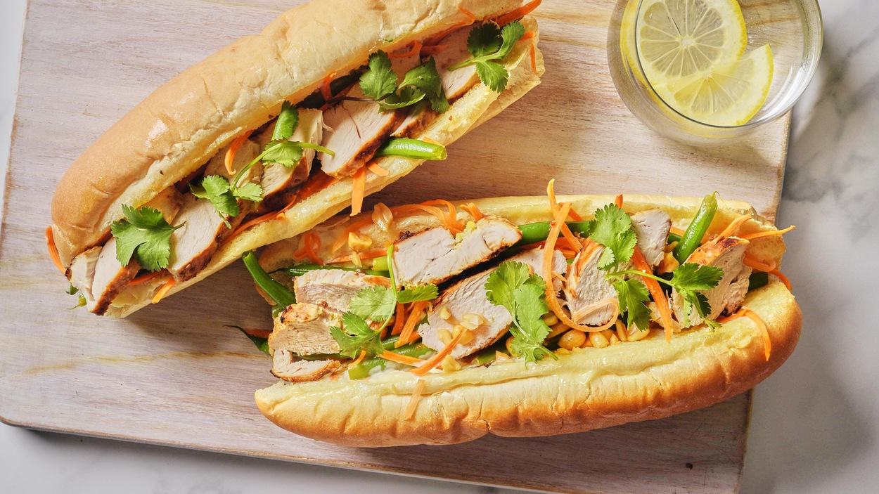 Deux sandwichs au poulet asiatique sur une planche.