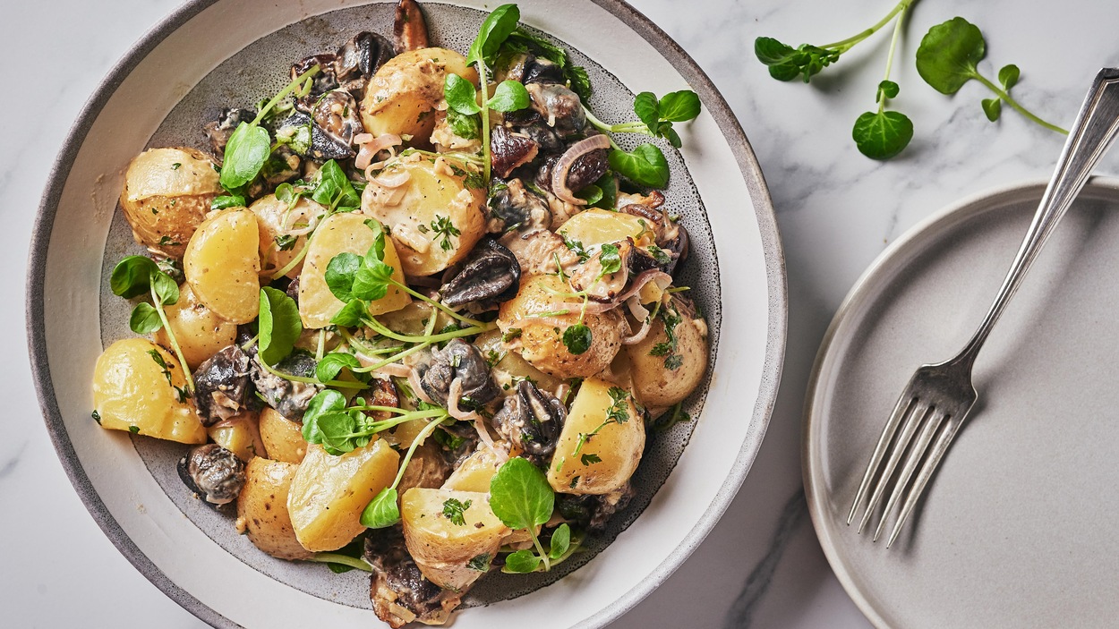 Une salade de pommes de terre et d'escargots dans une assiette.