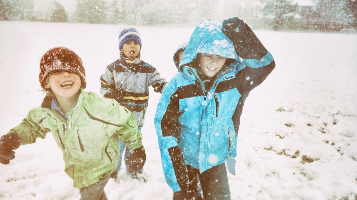 Des enfants rient en s'amusant dans la neige. Des enfants rient en s'amusant dans la neige.