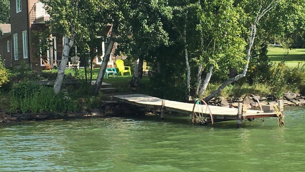 Lac verdâtre avec un quai flottant Lac verdâtre avec un quai flottant