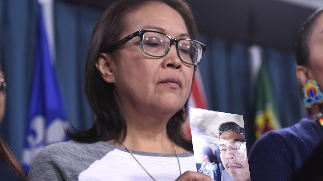 Debbie Baptiste, la mère de Colten Boushie, tenant une photo de son fils lors de la conférence de presse à Ottawa le 14 février 2018. Debbie Baptiste, la mère de Colten Boushie, tenant une photo de son fils lors de la conférence de presse à Ottawa le 14 février 2018.