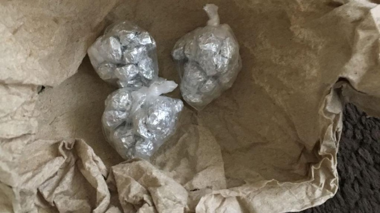 Trois petites boules enveloppées de plastique dont le contenu s'apparente à un type de drogue enveloppé dans du papier d'aluminium. Trois petites boules enveloppées de plastique dont le contenu s'apparente à un type de drogue enveloppé dans du papier d'aluminium.