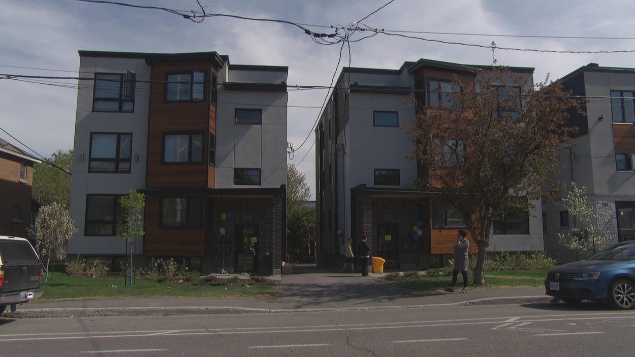 Vue frontale de deux immeubles de trois étages avec quelques étudiants inuits devant. Vue frontale de deux immeubles de trois étages avec quelques étudiants inuits devant.