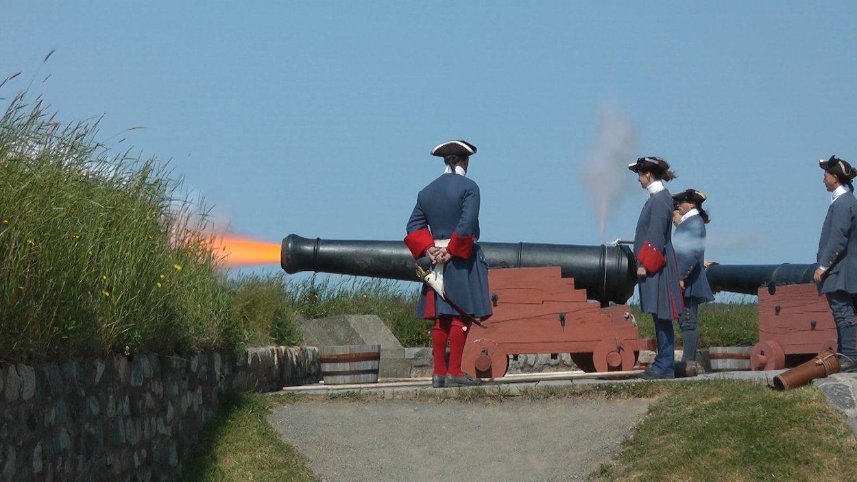 Des figurants en uniforme de soldat font tonner un canon sur un rempart Des figurants en uniforme de soldat font tonner un canon sur un rempart