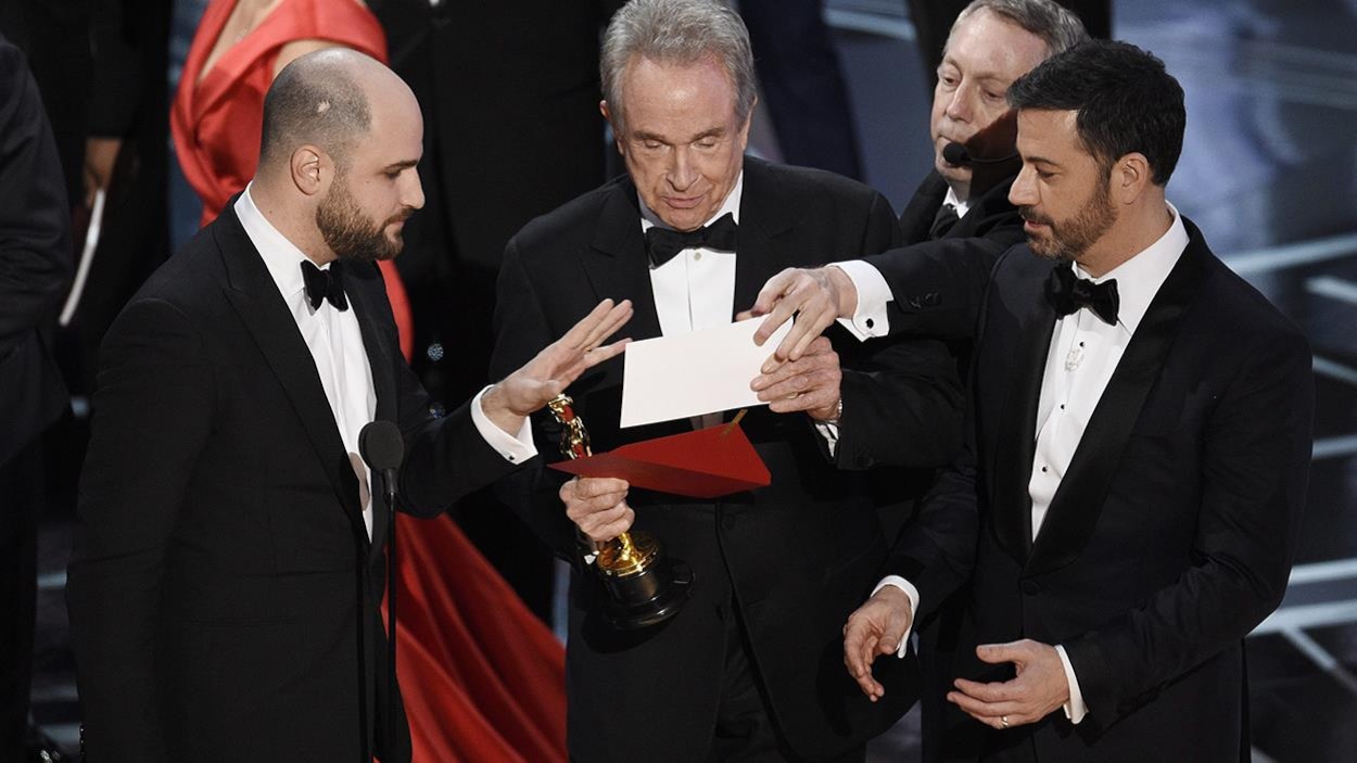Le producteur de « La La Land » Jordan Horowitz, le présentateur Warren Beatty et l'animateur Jimmy Kimmel regardent l'enveloppe annonçant « Moonlight » comme meilleur film aux Oscars, le 26 février 2017 Le producteur de « La La Land » Jordan Horowitz, le présentateur Warren Beatty et l'animateur Jimmy Kimmel regardent l'enveloppe annonçant « Moonlight » comme meilleur film aux Oscars, le 26 février 2017