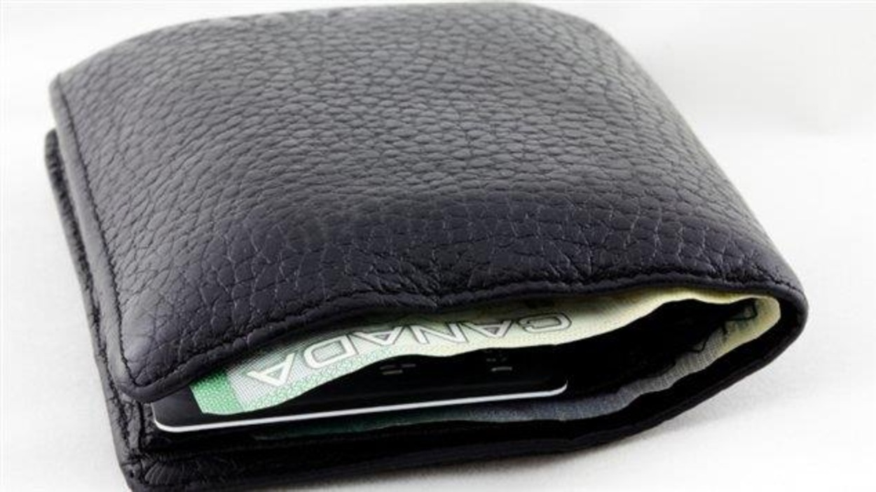 Un portefeuille duquel on voit dépasser un billet de banque canadien. Un portefeuille duquel on voit dépasser un billet de banque canadien.