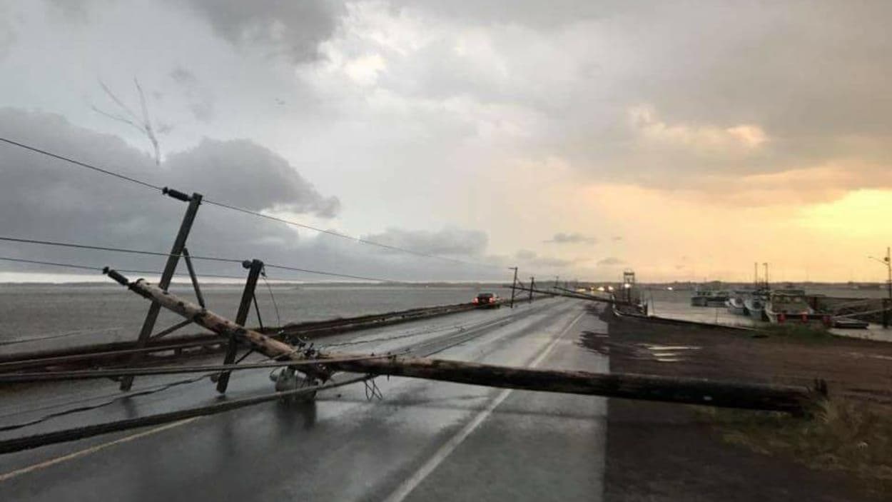 Des poteaux d'électricité au sol près du pont de Shippagan Des poteaux d'électricité au sol près du pont de Shippagan