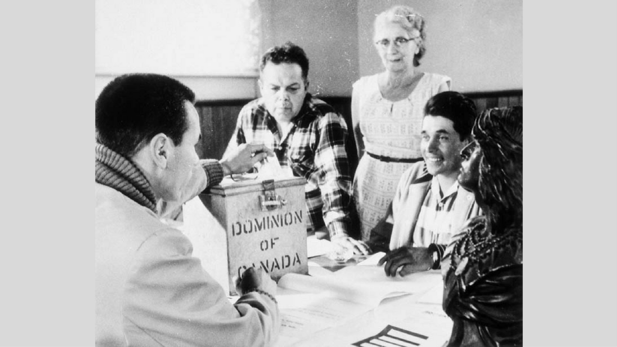 Photo de personnes qui déposent leur bulletin dans une urne. Photo de personnes qui déposent leur bulletin dans une urne.