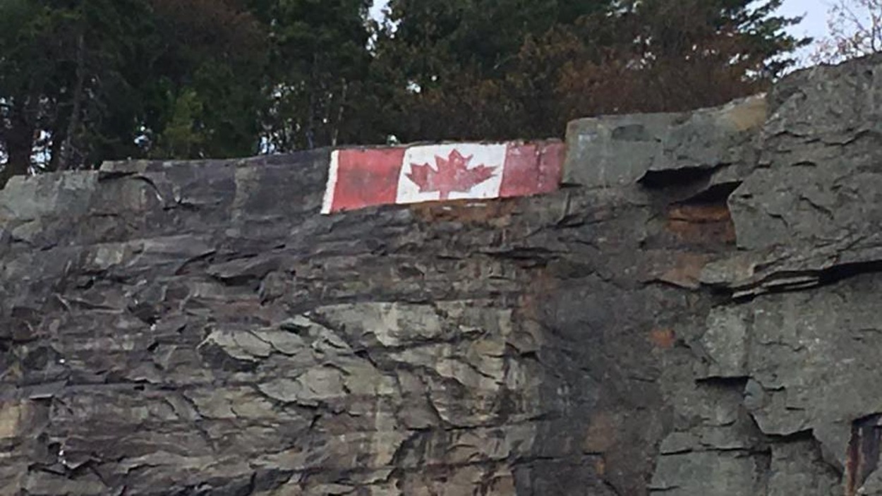 Un immense drapeau canadien est peint sur une falaise Un immense drapeau canadien est peint sur une falaise