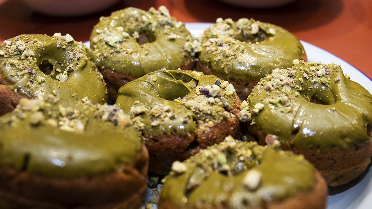 Les beignes végétaliens à l’orange et à la courgette, glaçage à la pistache de Caroline Huard. Les beignes végétaliens à l’orange et à la courgette, glaçage à la pistache de Caroline Huard.