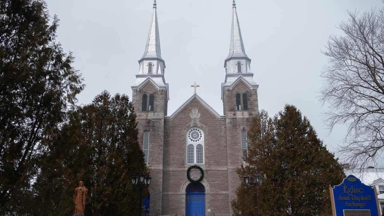 Une église en pierre grise à deux clochers. Une église en pierre grise à deux clochers.