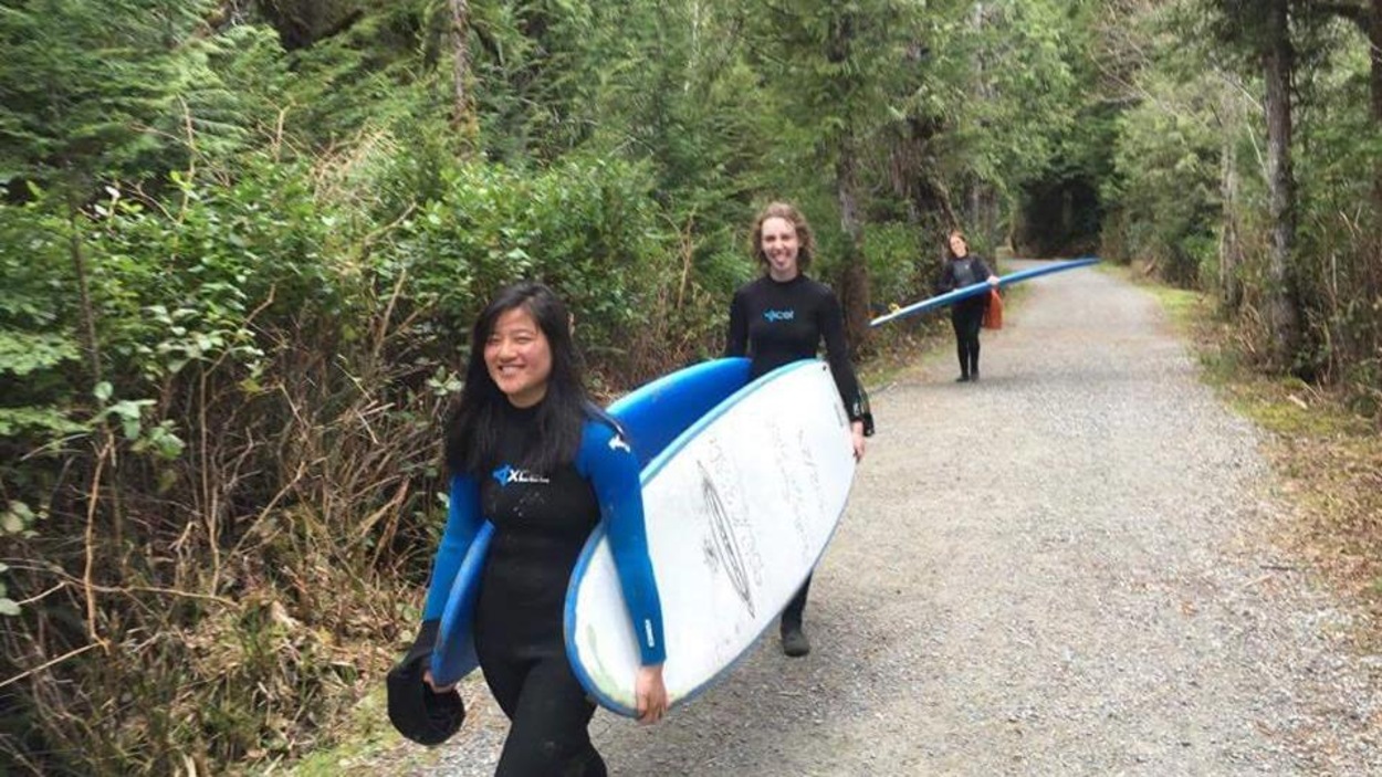 Sabrina Gagnon est ses amies transportent des planches de surf dans un sentier. Sabrina Gagnon est ses amies transportent des planches de surf dans un sentier.
