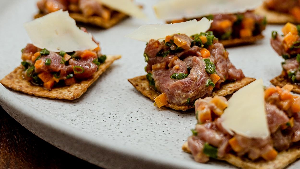 Des bouchées de tartare d’agneau aux carottes marinées, servies sur des craquelins maison. Des bouchées de tartare d’agneau aux carottes marinées, servies sur des craquelins maison.