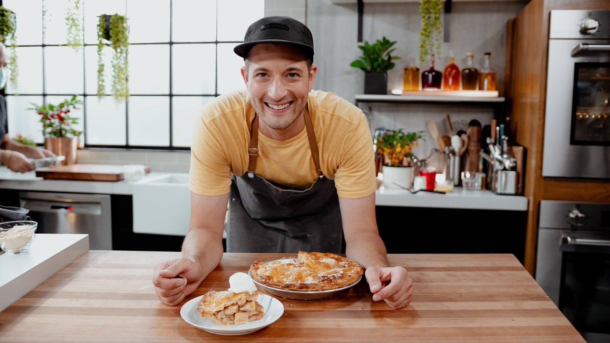Vincent Dion qui sourit devant sa tarte aux pommes.