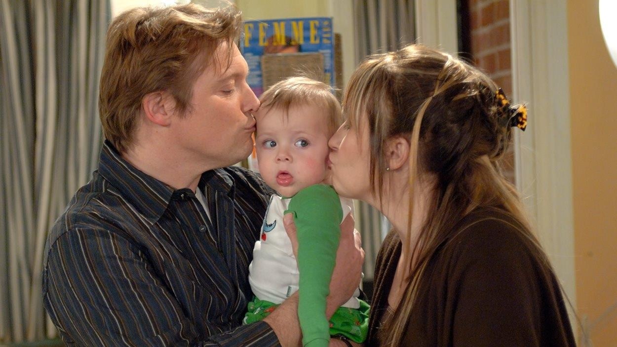 Marc et Susan embrassent chacun une joue de leur petit-fils Zac, bébé. Marc et Susan embrassent chacun une joue de leur petit-fils Zac, bébé.