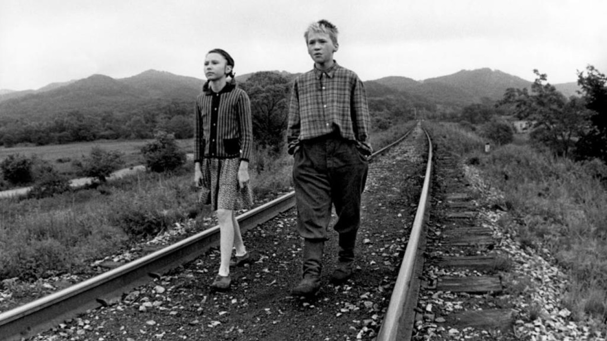 Une petite fille et un petit garçon marchent sur des rails. Une petite fille et un petit garçon marchent sur des rails.