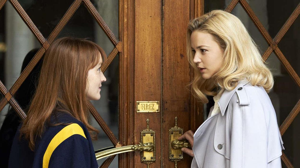 Devant une porte en bois, une femme blonde (Virgine Effira) parle à une jeune femme rousse (Anaïs Demoustier). Devant une porte en bois, une femme blonde (Virgine Effira) parle à une jeune femme rousse (Anaïs Demoustier).