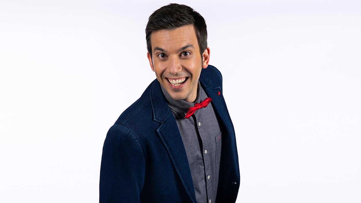 Le magicien sourit et porte une costume de soirée