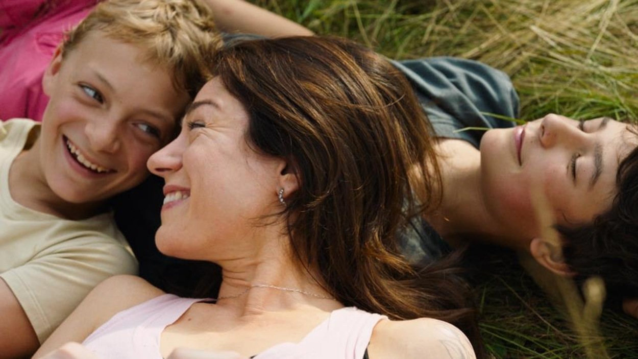 Une femme (Emilie Dequenne) et deux jeunes garçons allongés dans l'herbe. Une femme (Emilie Dequenne) et deux jeunes garçons allongés dans l'herbe.