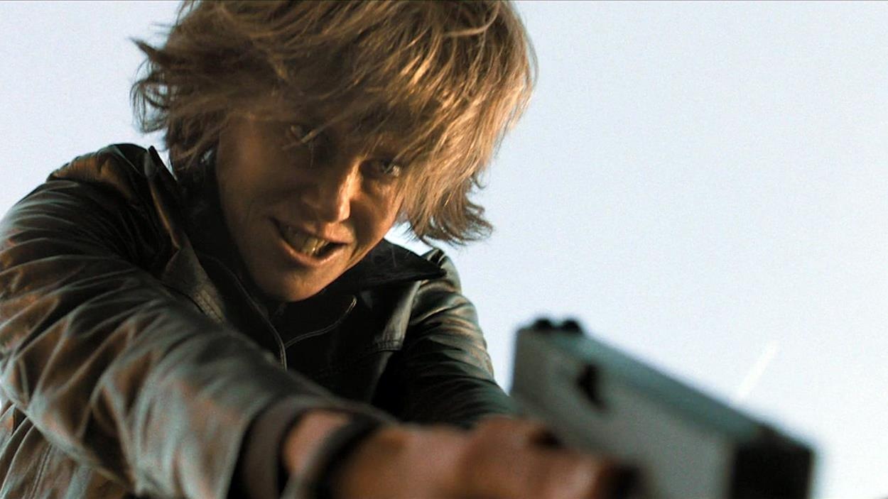 Une femme (Nicole Kidman) tient un pistolet et vise vers le bas, l'air concentré. Une femme (Nicole Kidman) tient un pistolet et vise vers le bas, l'air concentré.