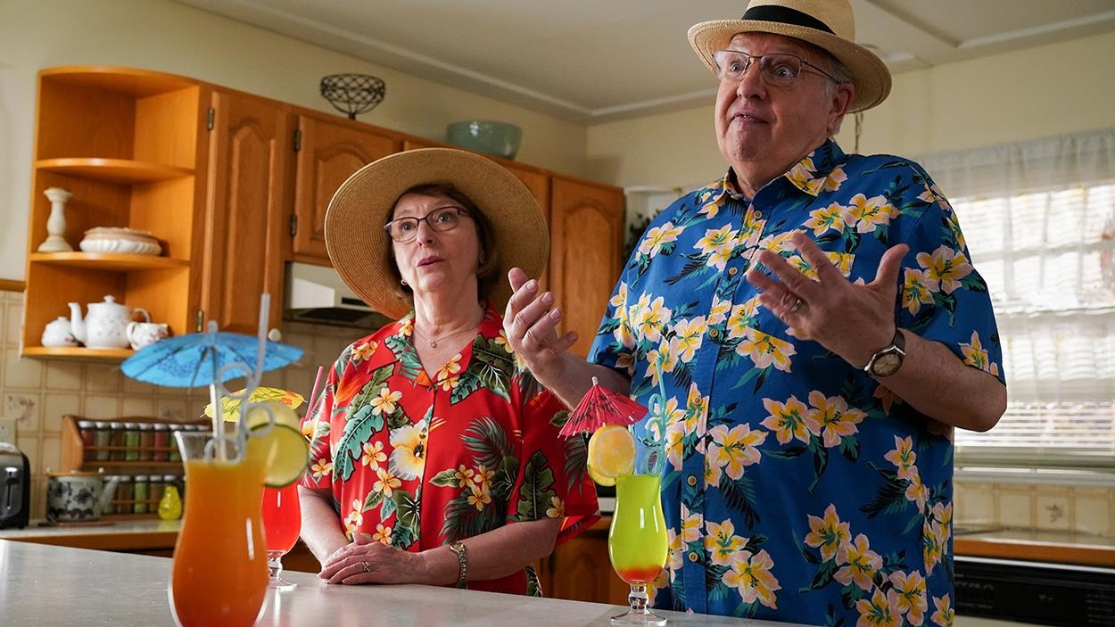 Rollande et Jean-Pierre habillé avec des vêtements fleuris, qui discutent de la Floride.