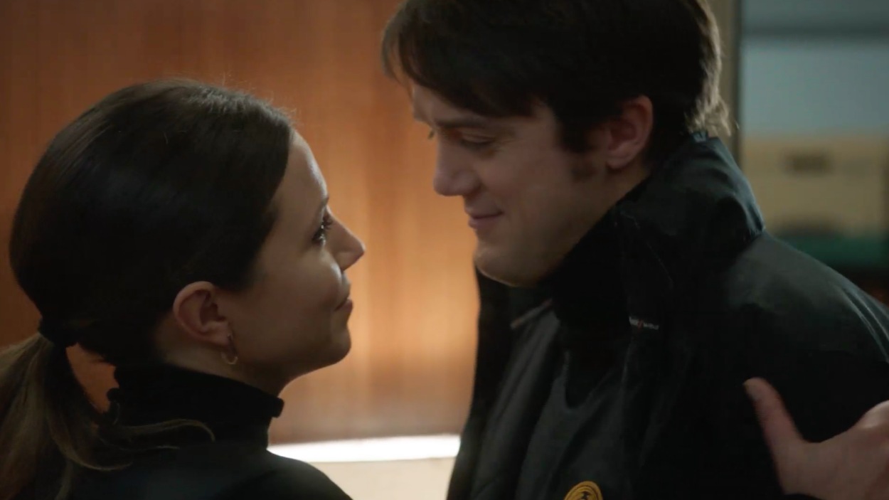 Nadine tient Patrick par l'épaule en le regardant dans les yeux. Nadine tient Patrick par l'épaule en le regardant dans les yeux.