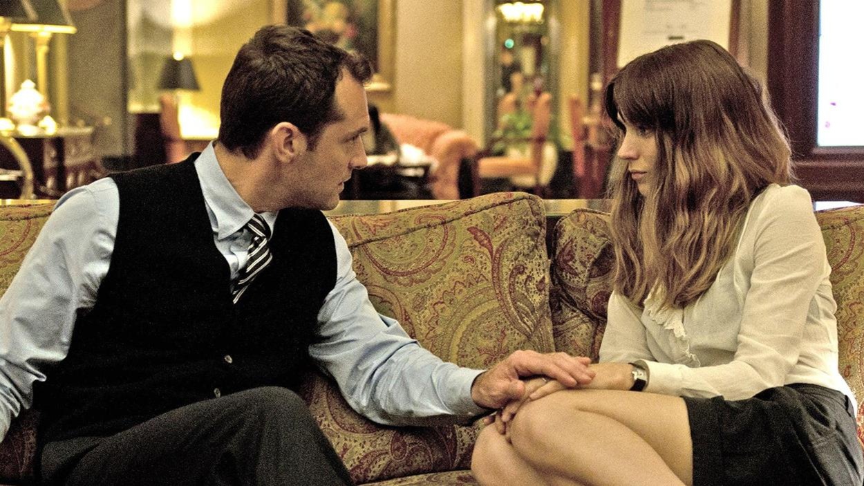 Un homme (Jude Law) et une femme (Rooney Mara) assis sur un canapé, lui ayant la main sur les siennes. Un homme (Jude Law) et une femme (Rooney Mara) assis sur un canapé, lui ayant la main sur les siennes.