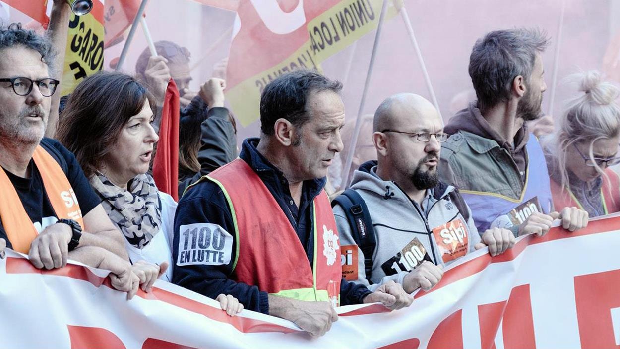 Un groupe de manifestants tenant une banderole Un groupe de manifestants tenant une banderole