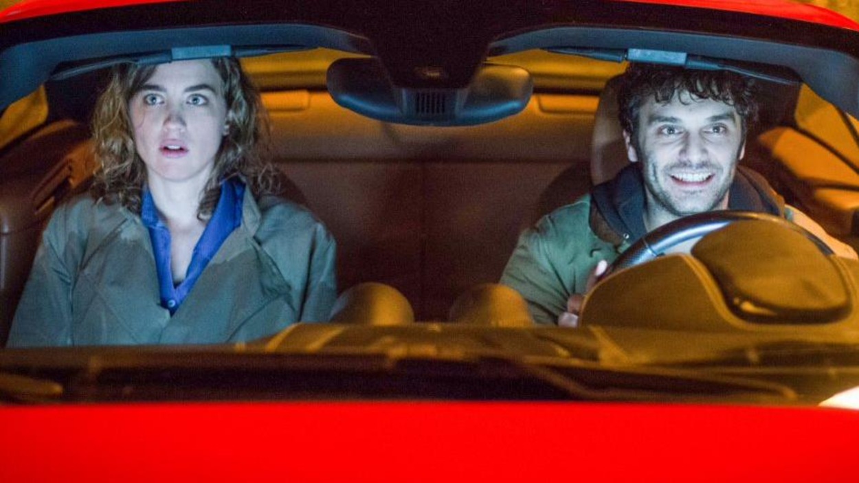 Un homme et une femme dans les sièges conducteur et passager d'une voiture rouge. Un homme et une femme dans les sièges conducteur et passager d'une voiture rouge.