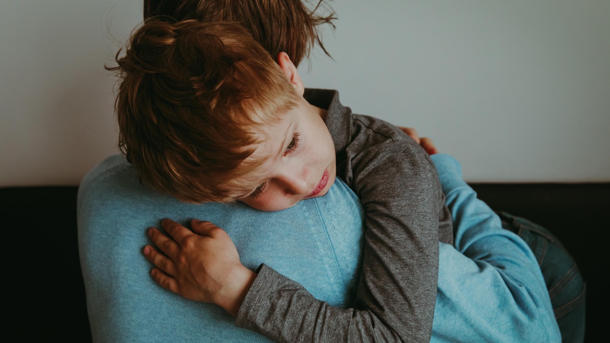 Un père porte dans ses bras son fils qui a de la peine. Un père porte dans ses bras son fils qui a de la peine.