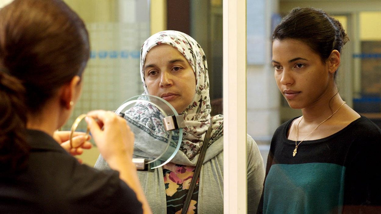 Une femme voilée et une jeune femme derrière un hygiaphone. Une femme voilée et une jeune femme derrière un hygiaphone.