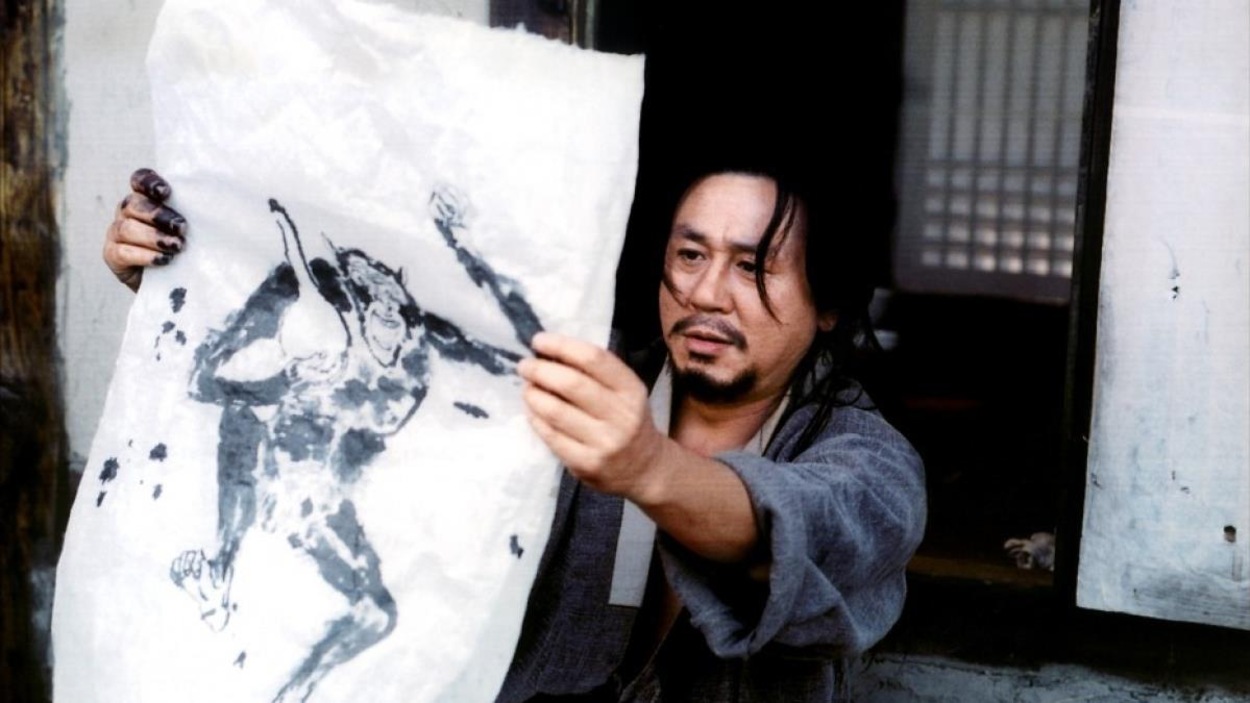 Un homme observe le dessin qu'il vient de faire sur une toile blanche Un homme observe le dessin qu'il vient de faire sur une toile blanche