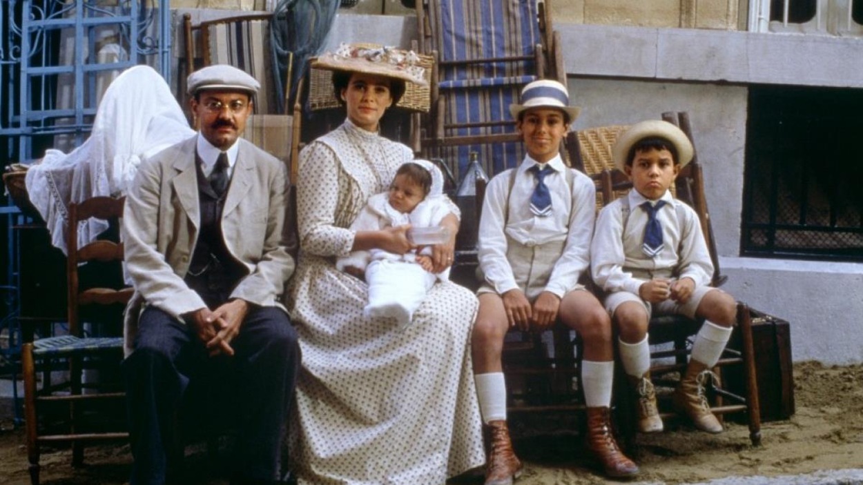 Une famille en habits d'époque assis et posant pour un photographe devant un tas de meubles dans la rue. Une famille en habits d'époque assis et posant pour un photographe devant un tas de meubles dans la rue.