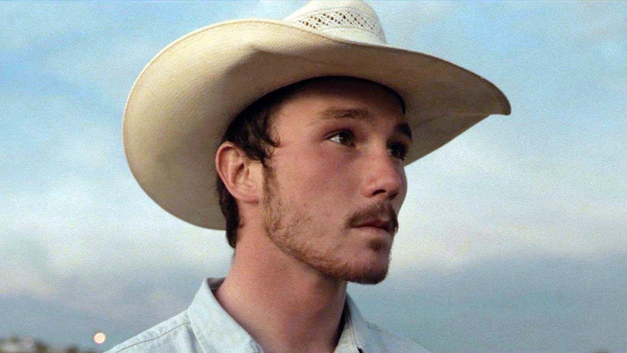 Un jeune homme portant un chapeau de cowboy, en gros plan, dans le soleil couchant. Un jeune homme portant un chapeau de cowboy, en gros plan, dans le soleil couchant.