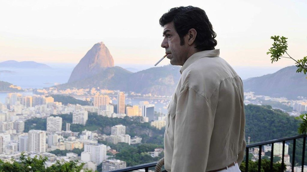 Un homme fume une cigarette sur un balcon surplombant la ville de Rio de Janeiro. Un homme fume une cigarette sur un balcon surplombant la ville de Rio de Janeiro.