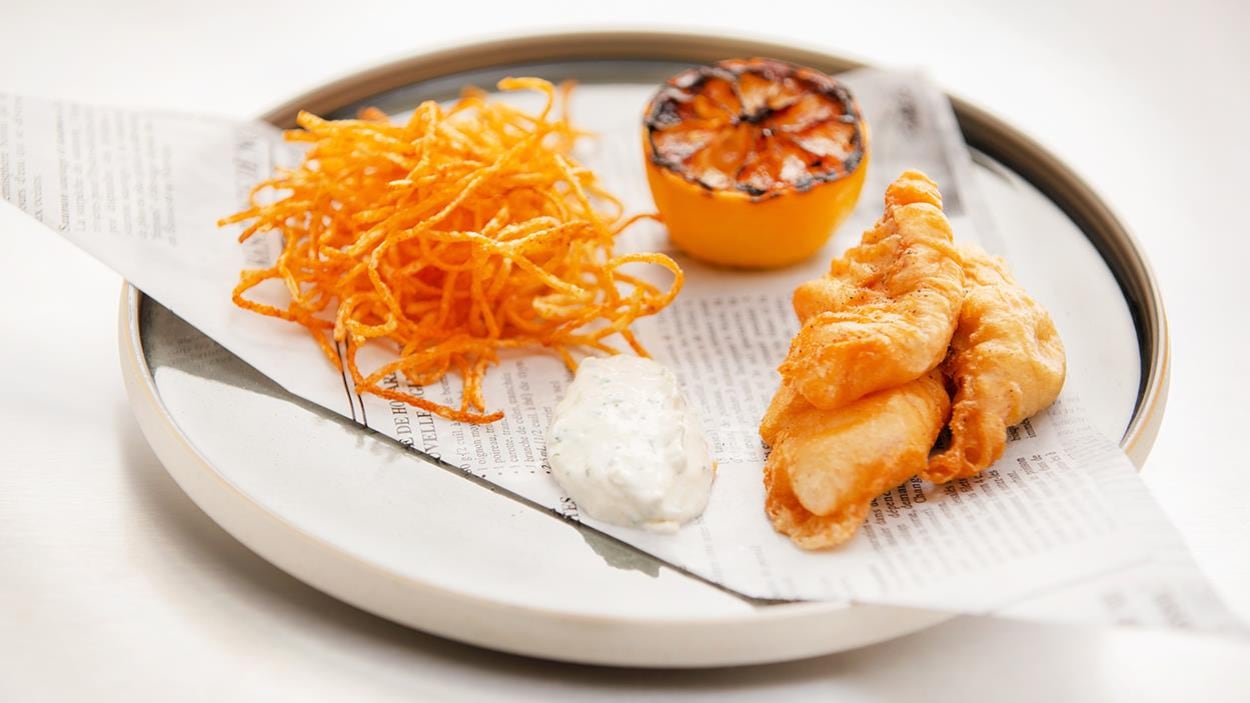 Une assiette de Fish and chips de truite arc-en-ciel avec un citron confit. Une assiette de Fish and chips de truite arc-en-ciel avec un citron confit.