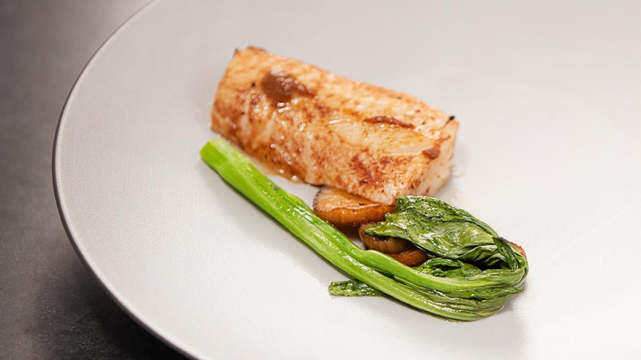 Une portion de morue charbonnière marinée aux umeboshi, pleurote érigé au miso, aubergine grillée au soya et long choi. Une portion de morue charbonnière marinée aux umeboshi, pleurote érigé au miso, aubergine grillée au soya et long choi.