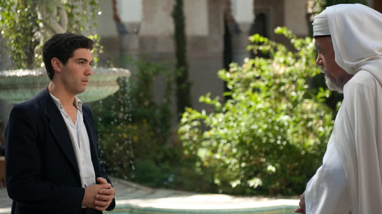 Dans un jardin, un homme en costume noir (Tahar Rahim) face à un imam en tenue blanche (Michael Lonsdale) Dans un jardin, un homme en costume noir (Tahar Rahim) face à un imam en tenue blanche (Michael Lonsdale)