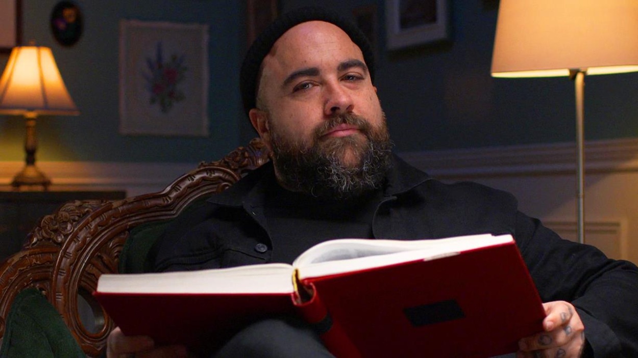 Jonathan Roberge, installé confortablement dans un fauteuil, tient un grand livre entre ses mains. Jonathan Roberge, installé confortablement dans un fauteuil, tient un grand livre entre ses mains.