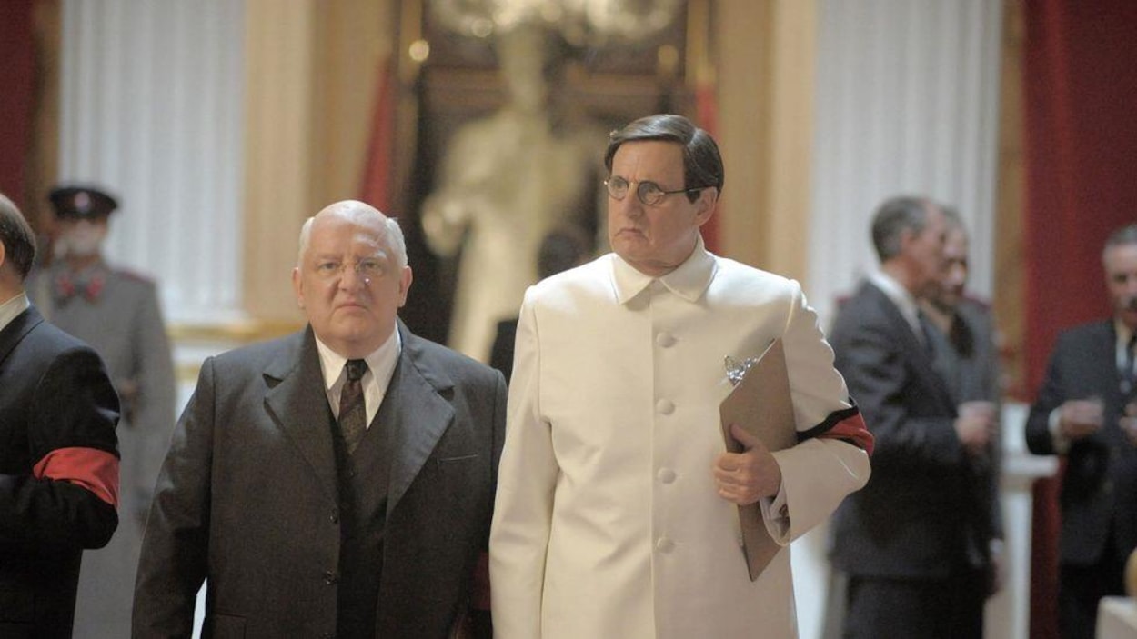 Un homme rond et petit se tient à côté d'un homme positive grand, habillé de blanc. Un homme rond et petit se tient à côté d'un homme positive grand, habillé de blanc.