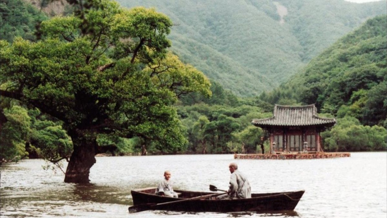 Un moine et son disciple dans une barque sur l'eau, au milieu de montagnes Un moine et son disciple dans une barque sur l'eau, au milieu de montagnes