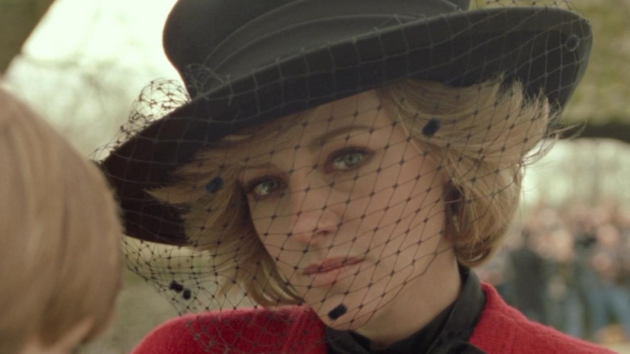 Une jeune femme blonde (Kristen Stewart), l'air triste, portant un chapeau à voilette. Une jeune femme blonde (Kristen Stewart), l'air triste, portant un chapeau à voilette.
